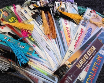 May include: A collection of colorful bookmarks with tassels. The bookmarks feature movie titles and images, including "Red Dawn", "McLintock", "The Movie", "Forbidden", "Back Hawk", and "The Shiners".
