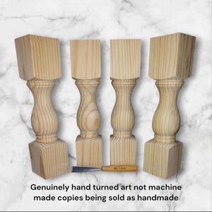 May include: Four unfinished wooden table legs with a turned design. The legs are made of light wood and have a square base. The text "Genuinely hand turned art not machine made copies being sold as handmade" is at the bottom of the image.