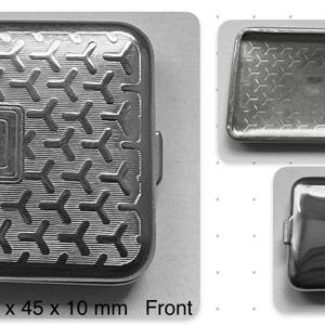 以下が含まれることがあります： 60 x 45 x 10 mmの銀色の金属製ピルケース。前面にはY字型の幾何学模様が繰り返され、中央に長方形の枠があります。背面は滑らかで光沢があります。内部には2つの白い仕切りがあります。