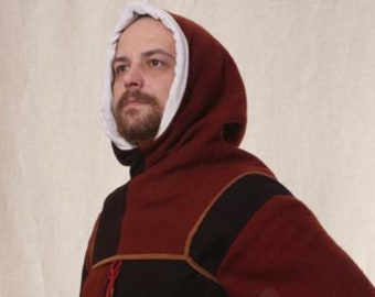 Op de afbeelding: Een man draagt ​​een rode en zwarte gekapte tuniek met een bruine leren riem en een dolk. De tuniek heeft een witte voering en een bruine leren bies.