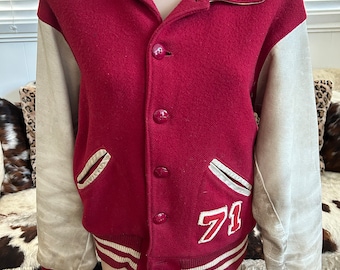 May include: A vintage maroon and cream-colored varsity jacket. The jacket features cream-colored sleeves, a maroon body, and a white and maroon striped hem and cuffs. The number "71" is stitched on the front.