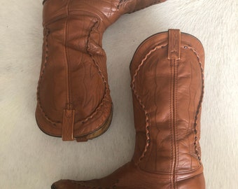 Tan vintage boots with ornate stitching detail.