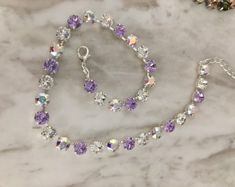 May include: A silver chain necklace with alternating clear and light purple crystal beads.
