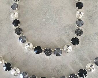 May include: A silver necklace and bracelet set with black, gray, and clear crystal beads.