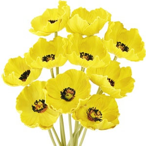Puede incluir: Un ramo de flores de amapola amarillas con centros oscuros. Las flores est&aacute;n dispuestas en un racimo, con los tallos visibles.