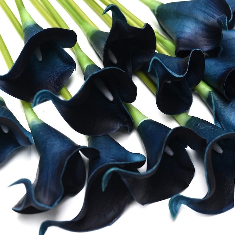 May include: A bouquet of dark blue artificial calla lilies. The flowers are made of a soft, velvety material and have a realistic appearance.