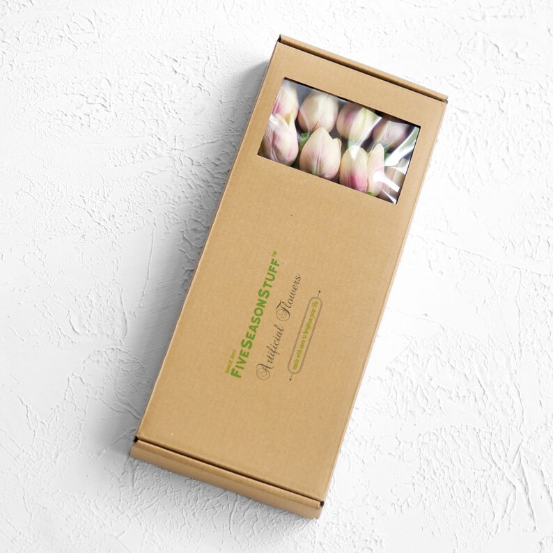 May include: A brown cardboard box with a clear plastic window showing a bouquet of pale pink artificial tulips. The box has a green logo that reads "FIVE SEASON STUFF" and "Artificial Flowers".
