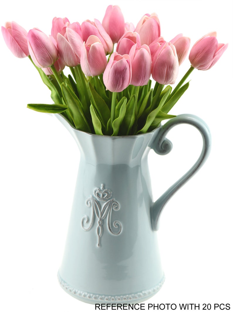 K&ouml;nnte beinhalten: Ein Strau&szlig; k&uuml;nstlicher rosa Tulpen in einem hellblauen Keramik Krug mit einem dekorativen silbernen Kronen- und Buchstaben M-Design. REFERENZFOTO MIT 20 ST&Uuml;CK