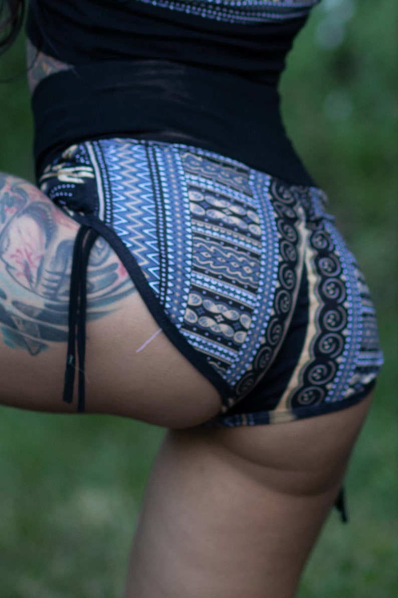 Puede incluir: Un par de pantalones cortos de color negro y azul con estampado geom&eacute;trico y un lazo en el lateral. Los pantalones cortos tienen un dise&ntilde;o geom&eacute;trico con detalles en negro, azul y blanco.