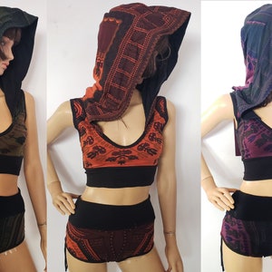 Puede incluir: Tres tops sin mangas con pantalones cortos a juego en diferentes combinaciones de colores. Los tops tienen un escote con capucha y una banda negra en la parte inferior. Los pantalones cortos tienen una cintura negra y cordones de ajuste en los lados. Los colores son verde, naranja y morado.