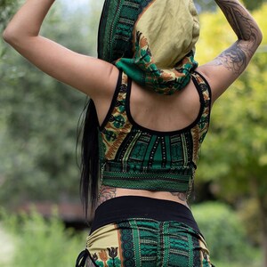 Puede incluir: Un top corto y pantalones cortos a juego con estampado verde y marr&oacute;n con una cintura negra. El top tiene un escote redondo y los pantalones cortos tienen un cord&oacute;n de ajuste en la cintura.