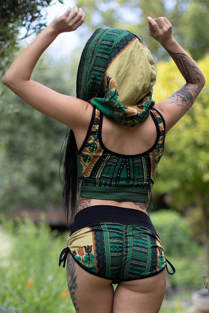 Puede incluir: Un top corto y pantalones cortos a juego con estampado verde y marr&oacute;n con una cintura negra. El top tiene un escote redondo y los pantalones cortos tienen un cord&oacute;n de ajuste en la cintura.