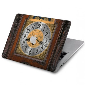 Könnte beinhalten: Ein Laptop mit einem Vintage-Zifferblattmuster auf dem Gehäuse. Das Zifferblatt hat römische Ziffern und ein Apple-Logo in der Mitte.