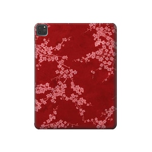 Puede incluir: Una funda de teléfono roja con un patrón floral rosa. La funda tiene un recorte para la lente de la cámara.