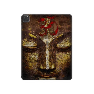 May include: A tablet case featuring a close-up of a Buddha face with closed eyes. The design includes a red Om symbol and gold leaf accents on a textured, brown background.