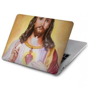 May include: A laptop computer with a colorful image of Jesus Christ on the lid. The image shows Jesus with a crown of thorns and a heart with flames on his chest.