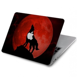 May include: A black laptop with a red moon and a wolf howling at the moon. The wolf's silhouette has an Apple logo in its chest.