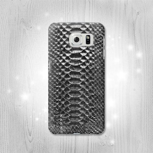 Könnte beinhalten: Schwarze Handyhülle mit Schlangenhautmuster.