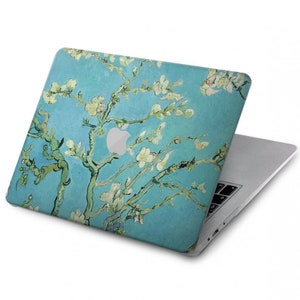 May include: A laptop computer with a blue and white floral design on the lid. The design features a painting of a tree with white blossoms.