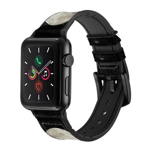 May include: Black Apple Watch with a black and white moon-patterned band. The watch face displays the time, date, and icons for phone, music, and heart rate.