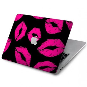 May include: A black laptop with a pink and black kiss print design on the lid. The Apple logo is visible on the lid.