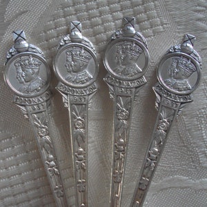 Pode incluir: Quatro colheres de prata com cabos ornamentados que apresentam um perfil de um rei e uma rainha com o texto "Coronation 1953".