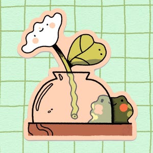 Op de afbeelding: Een sticker met een cartoonillustratie van een roze vaas met een witte bloem en een groen blad. Een groene kikker kijkt achter de vaas vandaan.