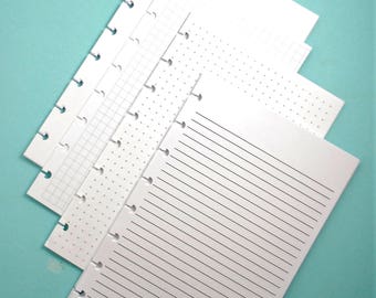 May include: Four white paper notebook refills with different page styles: blank, lined, grid, and dotted. The refills are designed for a disc-bound planner.
