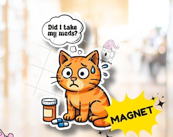 May include: A magnet featuring an orange cartoon cat with a worried expression, a thought bubble with the text 'Did I take my meds?', a pill bottle, and two pills. A small mug with a pink polka dot hat and the text 'The Sleepy Mug' is also visible.