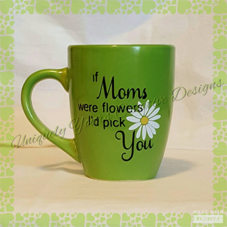 May include: Green ceramic mug with a white daisy and black text that reads "If Moms were flowers you'd pick You".