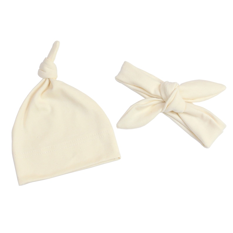 May include: A set of two off-white cotton headbands, one is a knotted beanie and the other is a headband with a bow.
