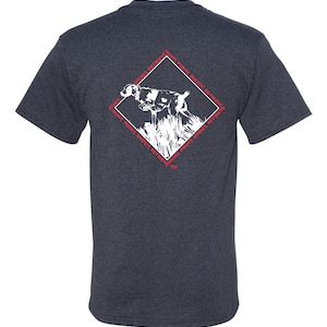 May include: A dark blue t-shirt with a white graphic of a dog pointing and a diamond-shaped design with the text "Hunt, Point, Shoot, Retrieve" repeated around the perimeter.