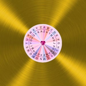 Könnte beinhalten: Ein rosa und weißes Rad mit Buchstaben des Alphabets am Rand. Das Rad hat ein rosa Herz in der Mitte.