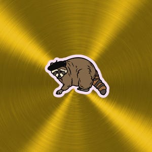 Puede incluir: Un mapache de dibujos animados con un gorro negro, con una cola rayada de marrón y blanco, sobre un fondo dorado.