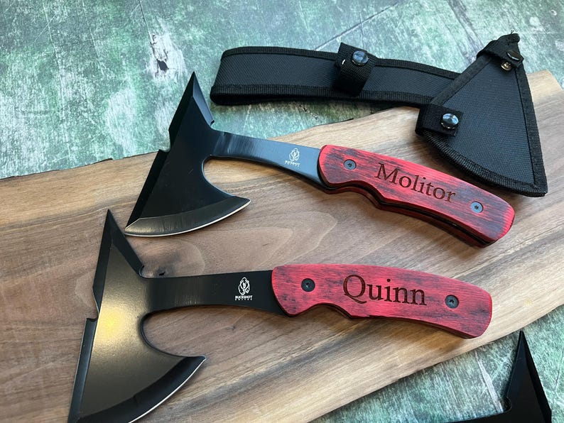 May include: Two black throwing axes with red wooden handles. The handles are engraved with the names "Molitor" and "Quinn".