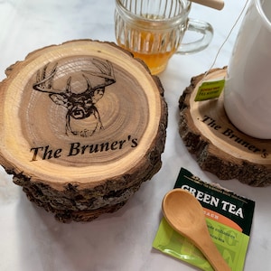 May include: Two wooden coasters with a rustic bark edge. The top coaster features a laser-engraved deer head with the text "The Bruner's". The bottom coaster has the text "The Bruner's" engraved on it.