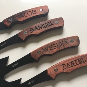 May include: Four black handled knives with wooden handles. Each handle has a different name engraved on it: Jacob, Samuel, Wesley, and Daniel.