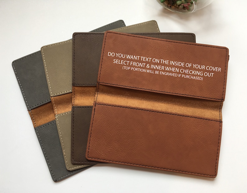 May include: Four rectangular checkbook covers in shades of gray, tan, dark brown, and light brown. The light brown cover features the text: DO YOU WANT TEXT ON THE INSIDE OF YOUR COVER SELECT FRONT & INNER WHEN CHECKING OUT (TOP PORTION WILL BE ENGRAVED IF PURCHASED).
