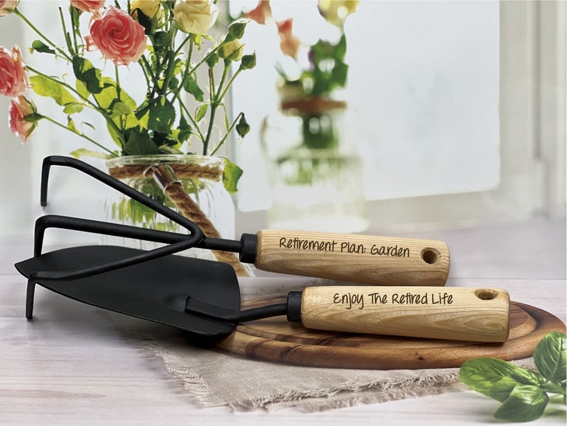 May include: A set of two gardening tools with wooden handles. The handles are engraved with the text "Retirement Plan: Garden" and "Enjoy The Retired Life".