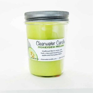 May include: A green glass candle jar with a silver lid. The label reads "Clearwater Candle Honeydew Melon" and describes the scent as "cool fresh, crisp scent kissed by green apples and Honeydew Melon".