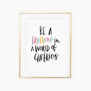 May include: A framed print with the text "Be a Fruit Loop in a world of Cheerios" in colorful, handwritten letters.