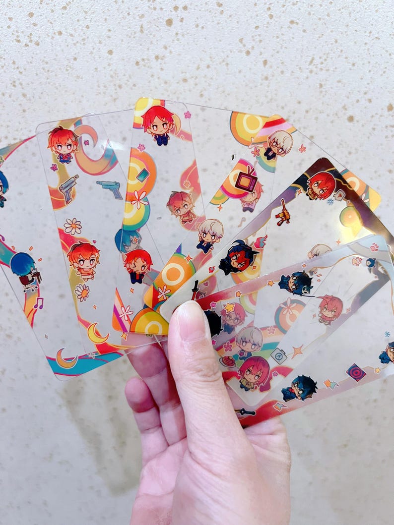 Puede incluir: Un conjunto de ocho tarjetas de pl&aacute;stico transparente con dise&ntilde;os de arco&iacute;ris coloridos y personajes de dibujos animados. Cada tarjeta presenta un personaje diferente con un dise&ntilde;o &uacute;nico.