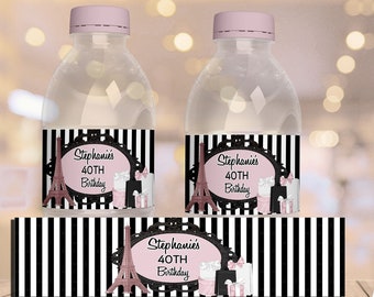 May include: Two clear plastic water bottles with black and white striped labels. The labels feature a pink Eiffel Tower graphic and the text "Stephanie's 40th Birthday".