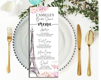 May include: Printable bridal shower menu template featuring a watercolor Eiffel Tower design with pink flowers. The menu includes appetizers, first course, main course, and dessert options. The text "Camille's Bridal Shower Menu" is at the top of the page.