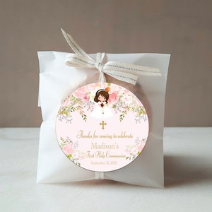 May include: A pink and white round favour tag with a floral design and a girl in a white dress. The tag says "Thanks for coming to celebrate Madison's First Holy Communion September 21, 2021".