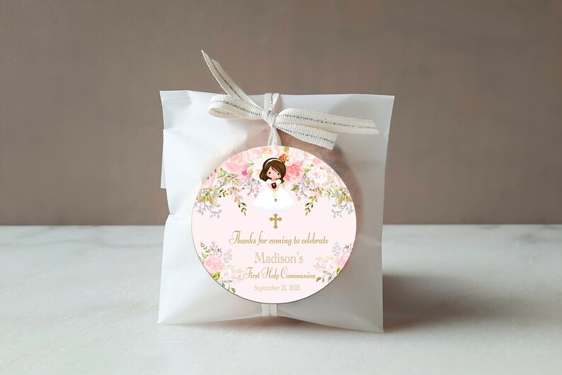 May include: A pink and white round favour tag with a floral design and a girl in a white dress. The tag says "Thanks for coming to celebrate Madison's First Holy Communion September 21, 2021".