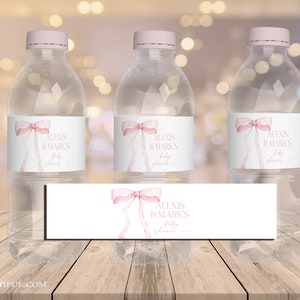 Könnte beinhalten: Drei klare Wasserflaschen mit rosa Schleifen- und Bogen-Etiketten, auf denen "Alexis & Mark's Baby Shower" steht.
