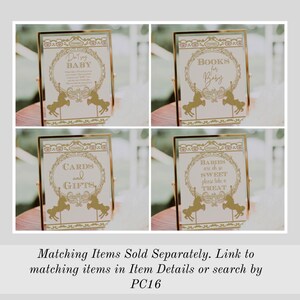 May include: Four gold framed signs with pink and gold accents. The signs have a carousel theme and feature the text "Don't Say Baby", "Books for Baby", "Cards and Gifts", and "Babies are oh so sweet please take a treat".