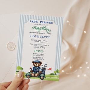 Peut inclure: Une invitation de fête prénatale à rayures bleues et blanches avec un ours en peluche en dessin animé conduisant un chariot de golf. L'invitation dit "Let's Par-Tee" et comprend le texte "Baby Shower" et "Honoring the parents to be Liz & Matt".