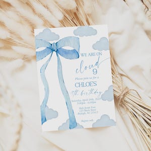 Peut inclure: Une carte d'invitation bleue et blanche avec une illustration aquarelle d'un nœud bleu et de nuages. Le texte sur la carte indique "We are on cloud 9. Please join us for Chloe's 9th birthday. Saturday, April 24th, 2023. 5:00pm - 6:00pm. 123 Main Street, Raleigh, NC 27611. RSVP only."